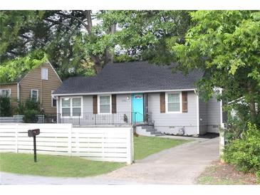 Charming single-story home with light gray exterior, cute shutters, and a vibrant blue front door at 3046 Dobbs Way, East Point, GA 30344