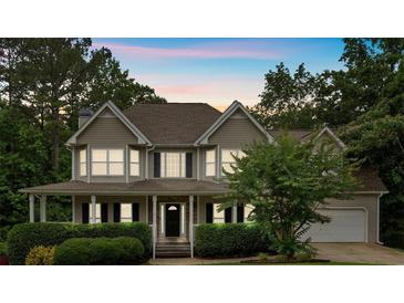 Charming two-story home with a welcoming front porch and manicured landscaping at 345 Riverstone Dr, Hiram, GA 30141