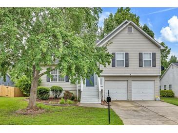 Charming two-story home featuring neutral siding, black shutters, two-car garage, and a well-manicured front lawn at 4435 Grove Nw Dr, Acworth, GA 30101