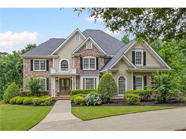 Charming two-story home featuring a well-manicured lawn, beautiful landscaping, and a welcoming front entrance at 7615 Laurel Oak Dr, Suwanee, GA 30024