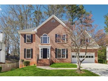 Charming brick two-story home with black shutters, black door, and well-manicured lawn at 4271 Weston Sw Dr, Lilburn, GA 30047