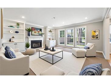 Bright living room featuring a fireplace, built-in shelves, and large windows offering plenty of natural light at 4271 Weston Sw Dr, Lilburn, GA 30047