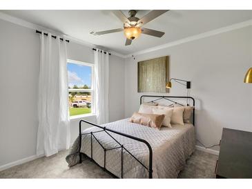 Cozy bedroom featuring a black metal bed frame, soft neutral bedding, and ample natural light from a window at 710 Pineberry Ct, Grayson, GA 30017