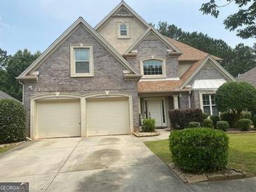 Charming two-story home with brick facade, well-manicured landscaping and an attached two-car garage at 7981 Gossamer Dr, Fairburn, GA 30213