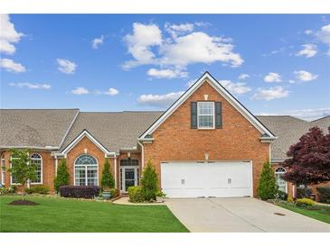 Charming brick home featuring an attached two-car garage, manicured lawn, and mature landscaping at 333 Lauren Ln, Woodstock, GA 30188
