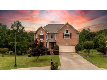 Charming two-story brick home with lush landscaping and a spacious driveway leading to a two-car garage at 638 Glen Valley Way, Dacula, GA 30019