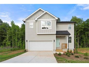 Charming two-story home with a two-car garage, light siding, and landscaped front yard at 4095 Oriole Ln, Fairburn, GA 30213