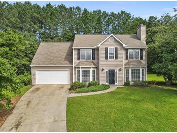 Charming two-story home features a manicured lawn, attached garage, and classic architectural details at 405 Mount Vernon Ct, Woodstock, GA 30189