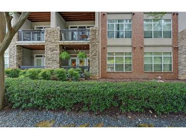 Stylish condo exterior featuring stone and brick accents, balconies, and lush landscaping at 840 United Ave # 113, Atlanta, GA 30312