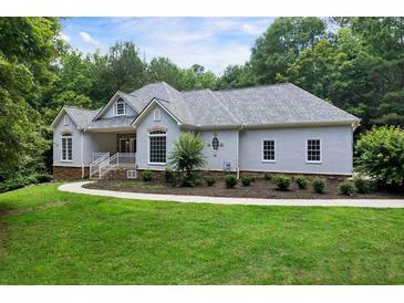Charming single-story home featuring a well-manicured lawn and traditional architectural details at 1460 Bakers Bridge Rd, Douglasville, GA 30134