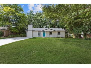 Charming single-story home featuring a well-manicured lawn and a striking blue front door at 4345 Sasanqua Ct, Tucker, GA 30084