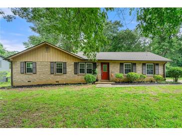 Charming brick home featuring a well-maintained lawn, trimmed shrubbery, and black shuttered windows at 165 Wellington Dr, Mcdonough, GA 30252