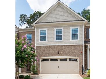 Attractive brick and siding exterior with a two-car garage and manicured landscaping at 203 Holden Way, Woodstock, GA 30189