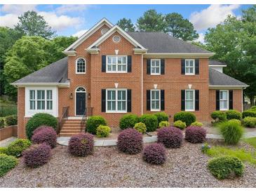 Beautiful brick home featuring a landscaped front yard with lush greenery and charming curb appeal at 1360 Wilmington Way, Grayson, GA 30017
