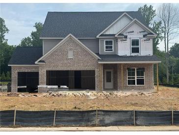 Two-story home featuring a gray color scheme, brick accents, an attached two car garage, and a dark roof at 5220 Birch Valley Rd, Cumming, GA 30028