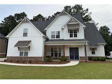 Charming two-story home featuring board and batten siding, stone accents, and a well-manicured lawn at 72 Hanover Dr, Villa Rica, GA 30180