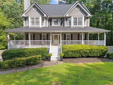 Charming two-story home featuring a welcoming front porch, well-manicured lawn, and lush landscaping at 150 Kensley Way, Dallas, GA 30157
