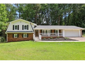 Charming two-story home with brick accents, white siding, and a welcoming covered front porch at 6000 Malibu Drive Dr, Morrow, GA 30260