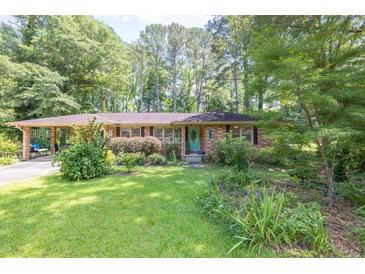 Charming brick ranch home with lush front yard and mature trees creating great curb appeal at 5400 Francis Ave, Stone Mountain, GA 30087