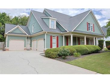 Charming two-story home with a manicured lawn, three car garage and inviting front porch with classic columns at 330 Bay Grove Rd, Loganville, GA 30052