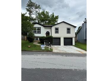 Charming home with a new white siding, black trim, and a two-car garage at 1340 Stoneleigh Way, Stone Mountain, GA 30088