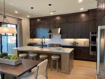 Stunning kitchen with stainless appliances, large island with counter seating, and dark wood cabinetry at 3010 Florence St, Cumming, GA 30041