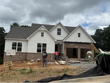 New construction home featuring white siding, brick accents, and an attached two-car garage at 202 Willow St, Canton, GA 30114