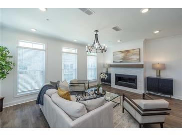 Bright living room featuring modern fireplace, stylish furnishings, and sleek hardwood floors at 1017 Crown Oak St # 50, Johns Creek, GA 30022