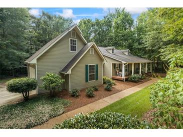 Charming exterior view of a two-story home with a inviting front porch and meticulously landscaped yard at 820 Airline Rd, Mcdonough, GA 30252