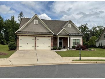 Charming home features a two-car garage, brick accents, and well-maintained landscaping at 1790 Nestledown Dr, Cumming, GA 30040