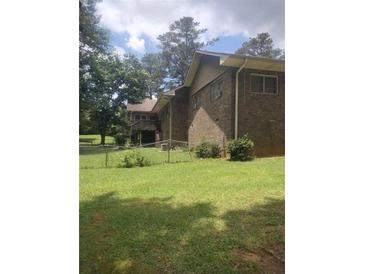 Brick home showing the backyard with a chain link fence at 1195 Christian Circle, Conyers, GA 30013