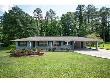 Charming home featuring a well-manicured front lawn and a covered carport, great curb appeal at 1305 Clay Sw Rd, Mableton, GA 30126