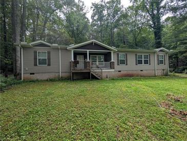 Charming single-story home with a inviting front porch, complemented by a large front yard surrounded by mature trees at 512 S Holly Springs Rd, Woodstock, GA 30188