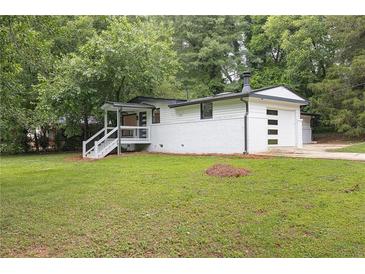 Charming one-story home with white painted brick, a side entry garage, and inviting front porch at 3042 Monterey Dr, Decatur, GA 30032