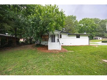 Charming home featuring a well-manicured lawn, inviting front entrance, and mature landscaping at 3042 Monterey Dr, Decatur, GA 30032