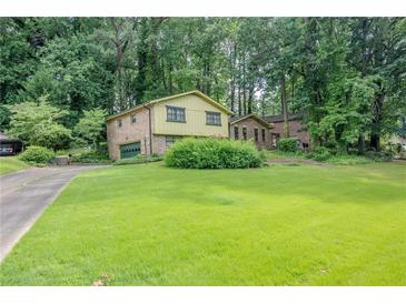 Two-story home featuring a large front lawn and mature trees around the property at 3206 Pyrite Sw Cir, Atlanta, GA 30331