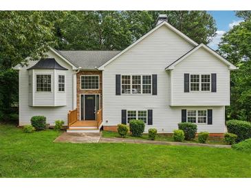 Charming two-story home boasts manicured lawn, white siding, black shutters, and inviting entrance at 4958 Alpine Ct, Winston, GA 30187