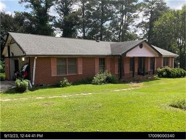 Charming single-story brick home featuring shuttered windows, covered carport, and a cozy front porch at 2969 Favor Sw Rd, Marietta, GA 30060