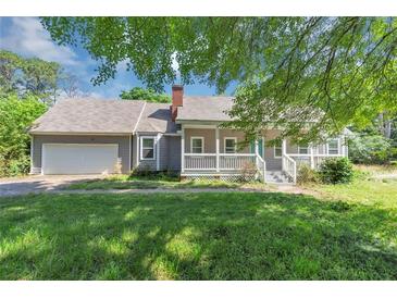 Charming single-story home with a covered porch, attached garage, and well-maintained lawn at 6744 Rockbridge Rd, Stone Mountain, GA 30087