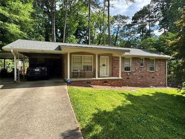 Charming brick home with carport, inviting front porch, and well-manicured lawn at 2543 Asbury Court Ct, Decatur, GA 30033
