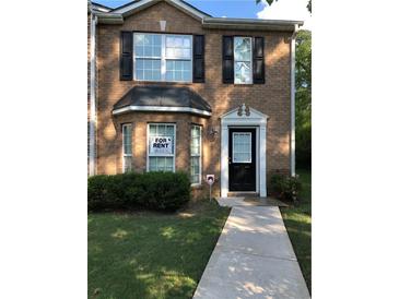 Traditional brick home featuring well-maintained landscaping and a welcoming entrance at 8430 Carlington Ln, Jonesboro, GA 30236