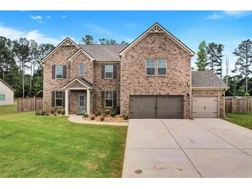Charming two-story brick home with a three-car garage and well-manicured lawn at 109 Jodi Pl, Locust Grove, GA 30248