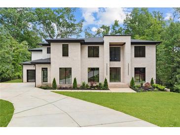 Elegant modern home with a painted brick facade, manicured lawn, and a circular driveway at 4125 Ashwoody Ne Trl, Brookhaven, GA 30319