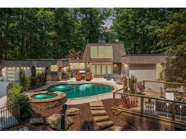Stunning backyard with pool, spa, deck, and lush greenery for ultimate relaxation and entertainment at 4850 Lake Fjord Pass, Marietta, GA 30068