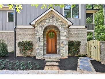 Charming stone archway frames the wooden front door, set in a landscaped front yard at 2179 William Way, Atlanta, GA 30345