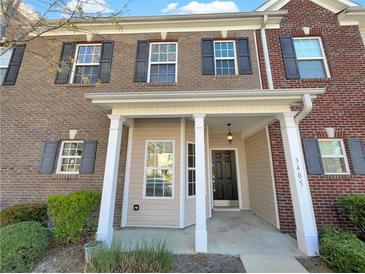 Charming brick townhome with inviting covered porch and well-maintained landscaping at 2555 Flat Shoals Rd # 3405, Atlanta, GA 30349