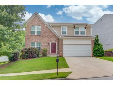 Charming two-story home with a brick facade, manicured lawn, and a two-car garage at 1727 Shire Village Dr, Sugar Hill, GA 30518