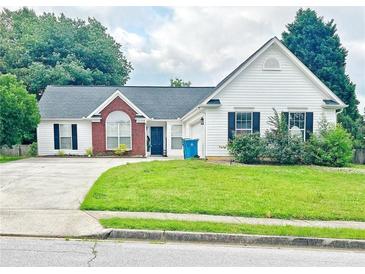 Charming single-Gathering home with a well-manicured lawn, attached garage and a classic brick and vinyl facade at 2647 Midler Ct, Buford, GA 30519