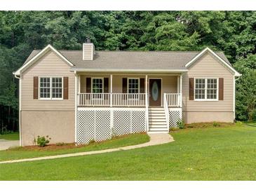 Charming home featuring a covered porch, white railings, and a well-maintained lawn at 225 Hitchcock Dr, Villa Rica, GA 30180