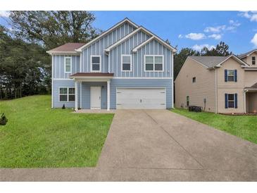 Charming blue two-story home with a well-manicured lawn and a two car garage at 4401 Belcamp Rd, Union City, GA 30213